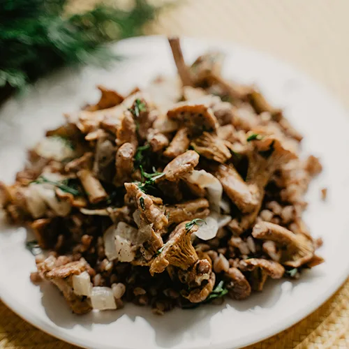 Girolles poêlées et servies avec du persil frais au restaurant La Table de Trois à Bordeaux